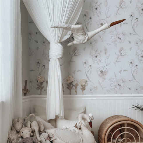 A light coloured nursery with sketched floral wallpaper