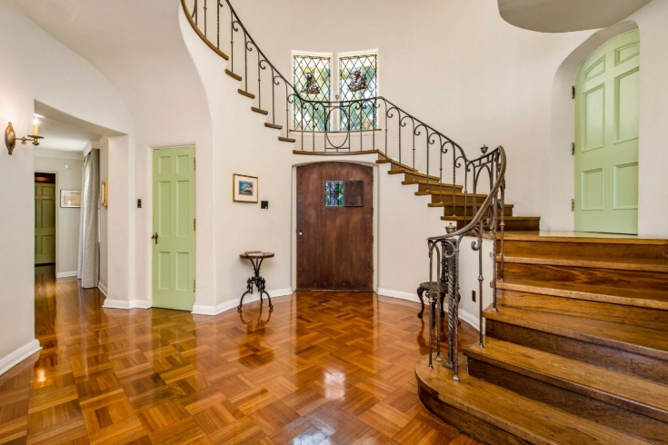 A spiral wooden staircase with intricate metal railings and stained glass windows