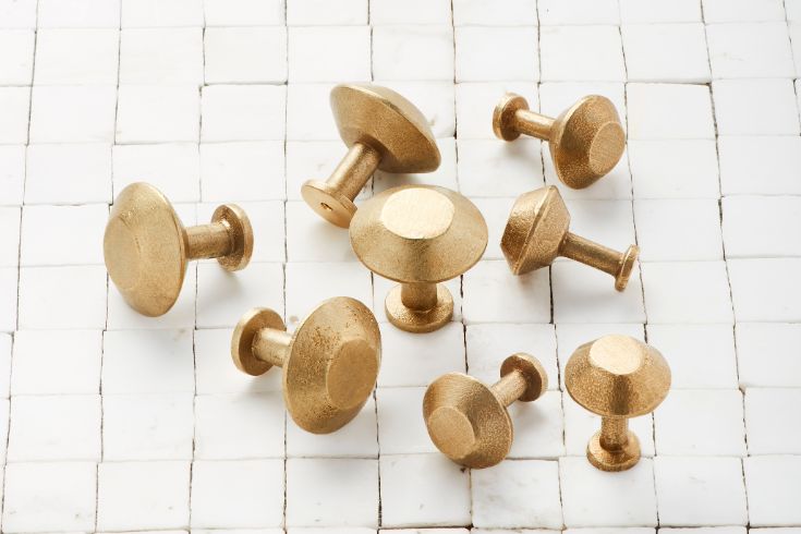 Shayne Hardware SPUL brass knobs on white tiled floor