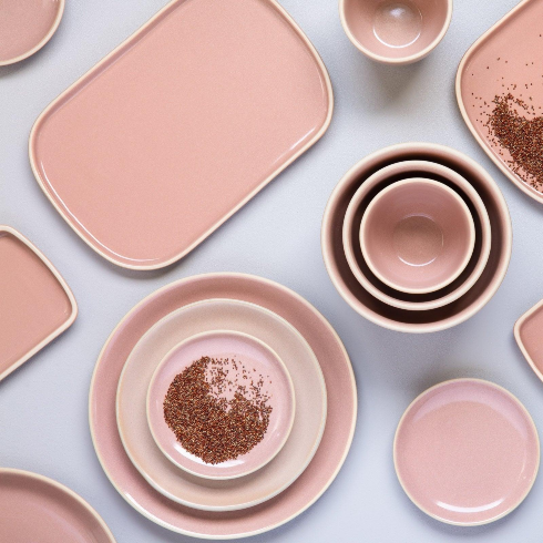 A set of dishware in various shades of light pink