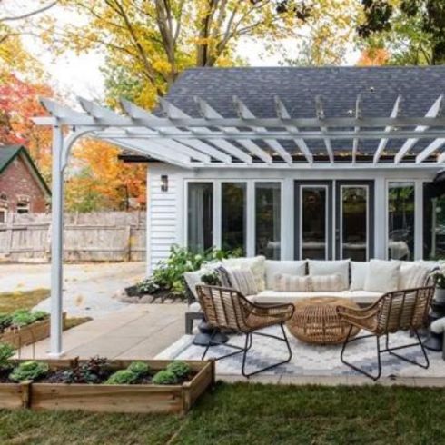 Modern backyard with white pergola, modern furniture and elevated furniture.