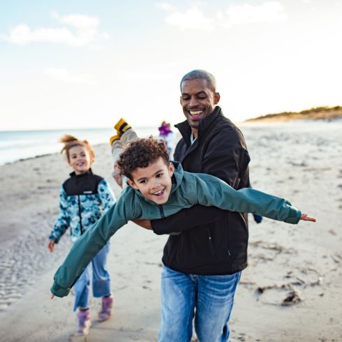 Dad playing with kids on the beach