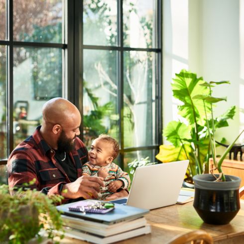 Dad holding kid on his lap in the dining room