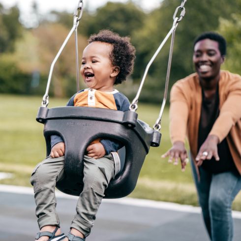 Dad swinging baby at the park