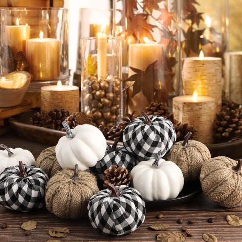 Decorative small plaid, burlap and white faux pumpkins on table.