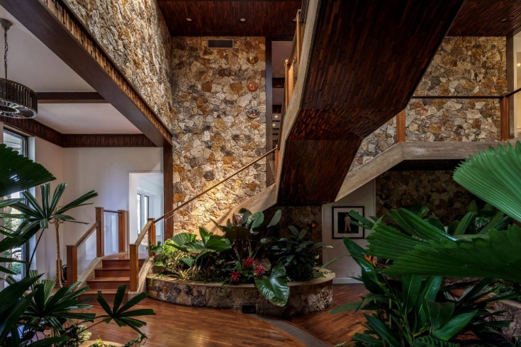 A foyer with stone walls and a floating staircase