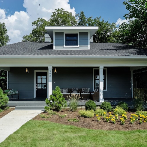 A modern white, blue and grey house with simple landscaping