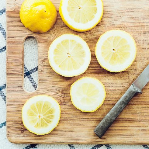 Cut lemon slices on wooden cutting board