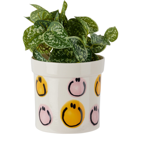 A white ceramic planter with quirky colourful smiley faces