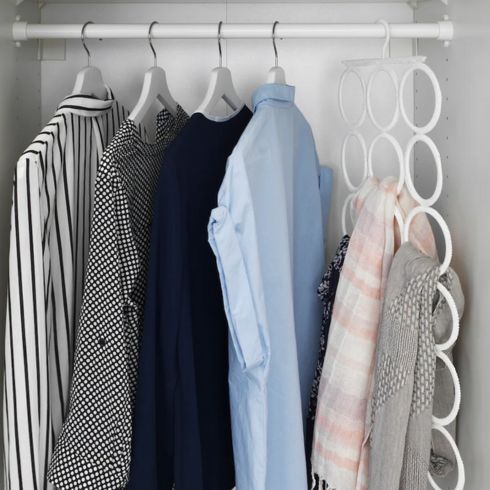 Multi-use hanger in closet hanging scarf with clothes nearby.