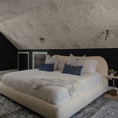 Attic bedroom with wallpaper on the ceiling