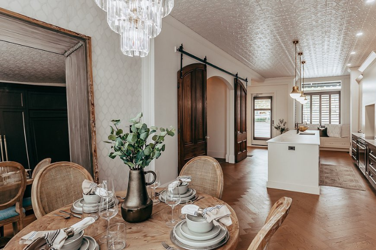 Bright dining and kitchen with deep wood tones and a chandelier at <yoastmark class=