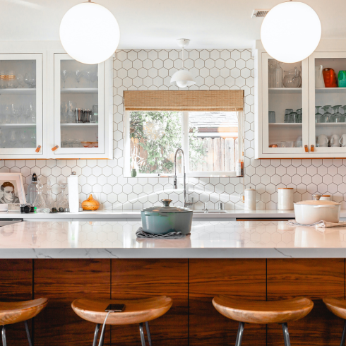 A modern kitchen island with bar stools next to it