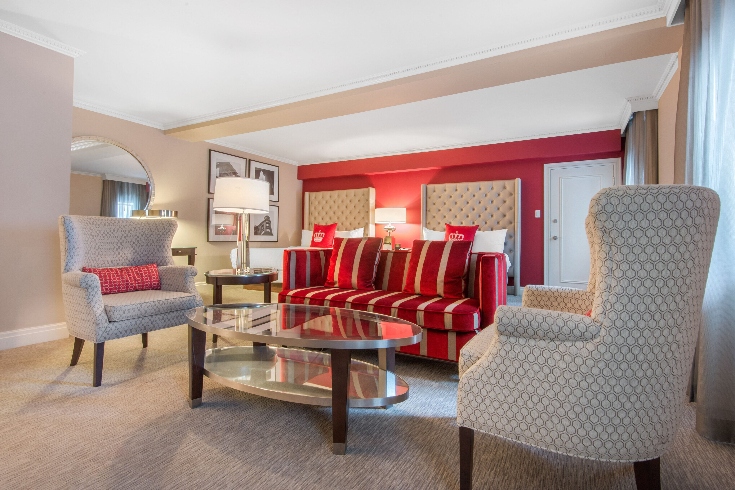 A hotel room with red accent wall