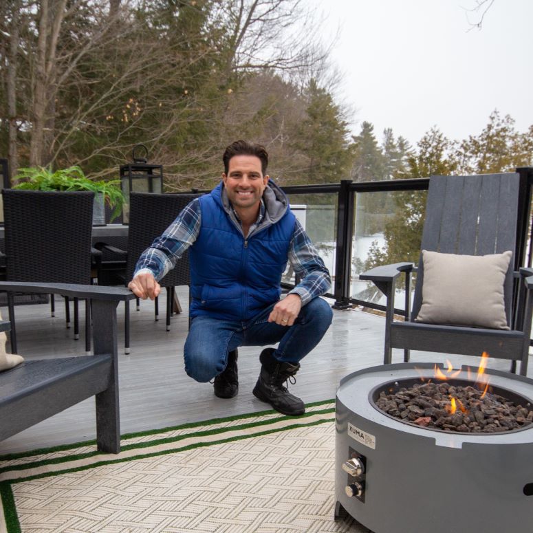 Scott McGillivray on a renovated deck, next to a fire pit