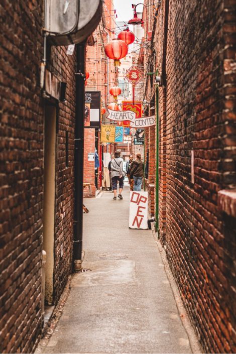 Picture of people walking down an alleyway in a large city