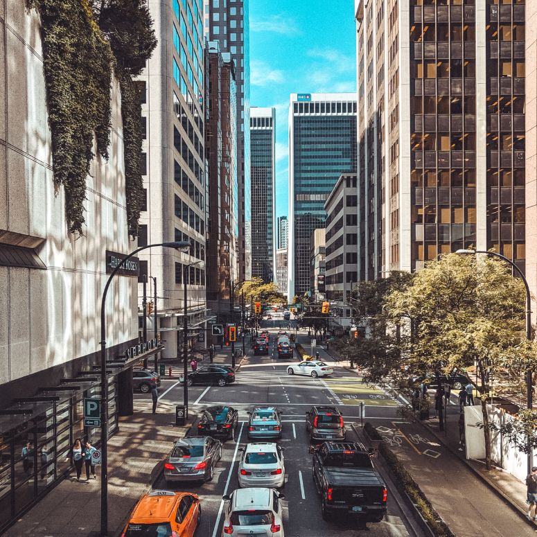 A view of a city with skyscrapers lining the streets and lots of cars on the road