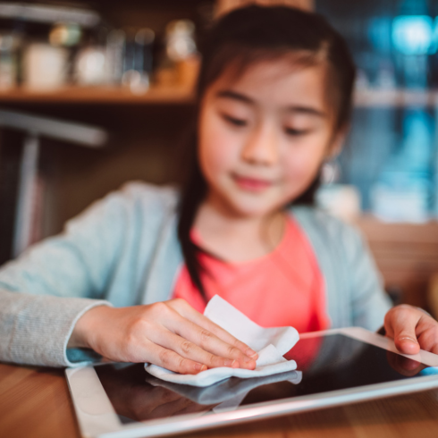 young Asian girl wiping her iPad with a dry cloth