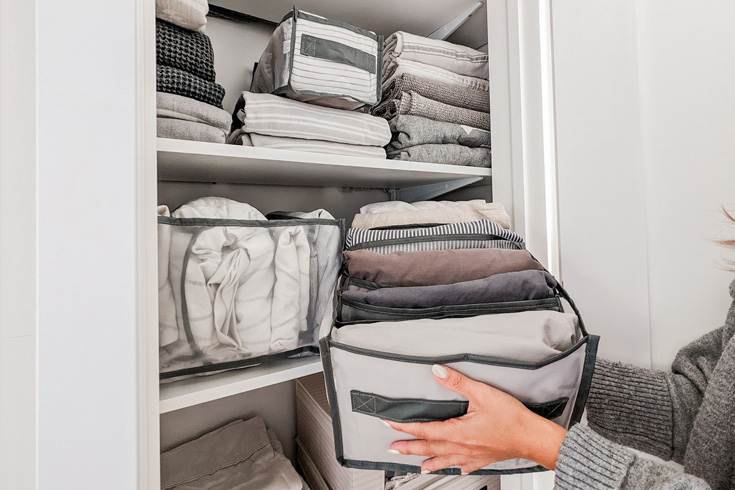 Woman organizing small linen closet