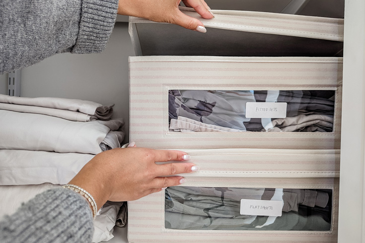Woman organizing a small linen closet