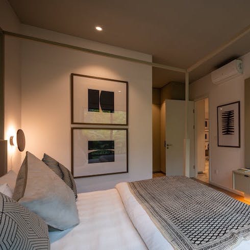 A cozy bedroom with a white bed and a grey ceiling