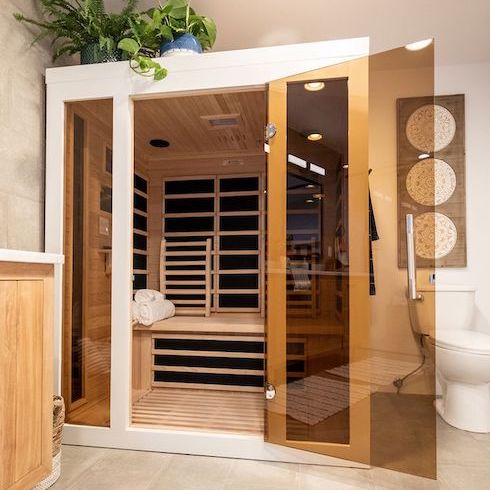 A wood-framed infrared sauna in a spa-like bathroom