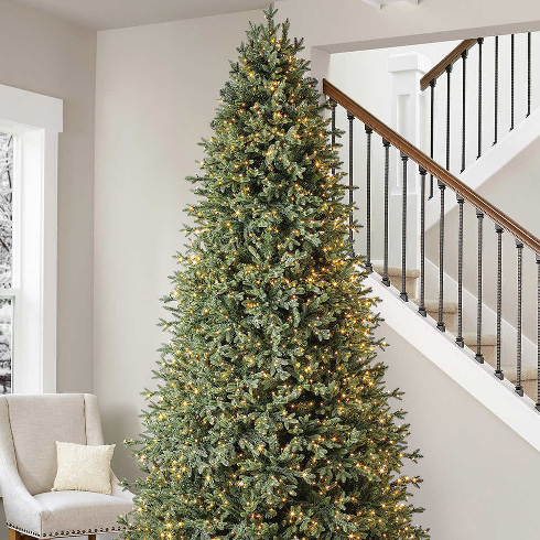 A 9-foot tall Christmas tree near a staircase