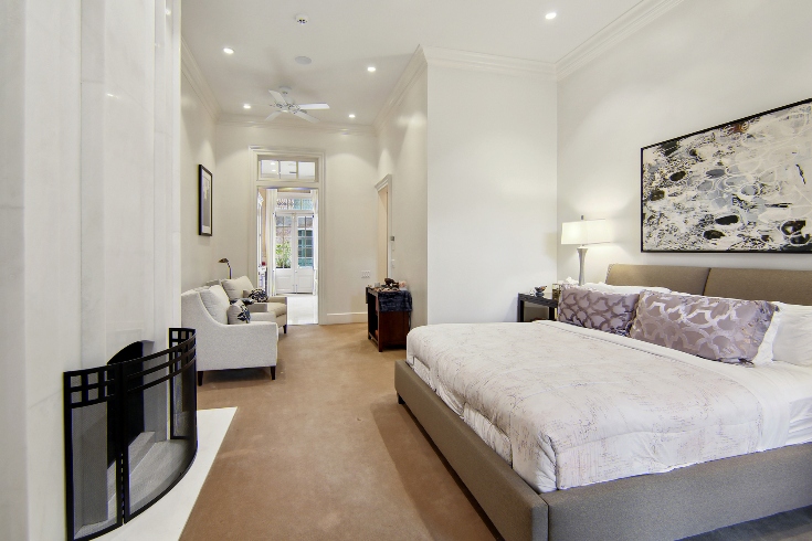 An owner’s suite with white marble fireplace, crystal chandeliers, antique sconces and a King-sized bed.