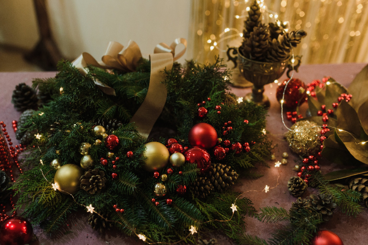 A holiday tablescape with wreath, Christmas ornaments and string lights