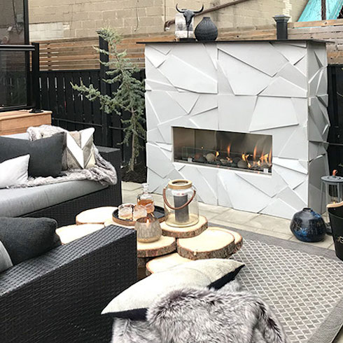 An outdoor fireplace surrounded by rustic furniture and lanterns