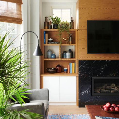 Fireplace flanked by walnut wood shelves