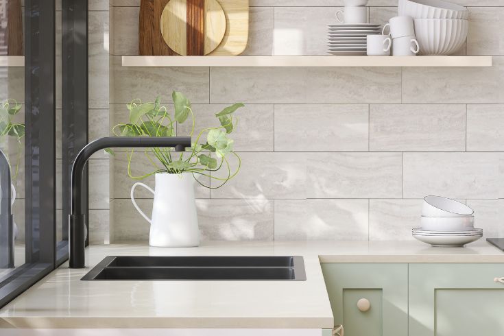 Modern white kitchen with sage cupboards, open shelving and modern black sink
