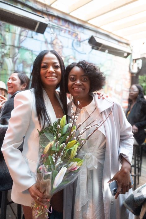 Nicole Babb and Nike Onile together with flowers
