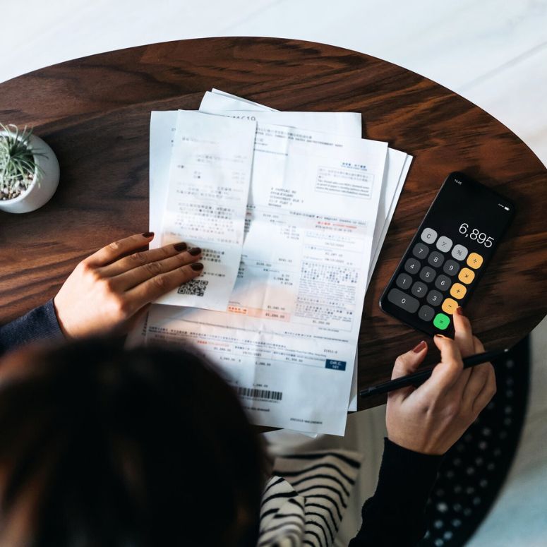 Lady working out financial bills and calculating costs with calculator