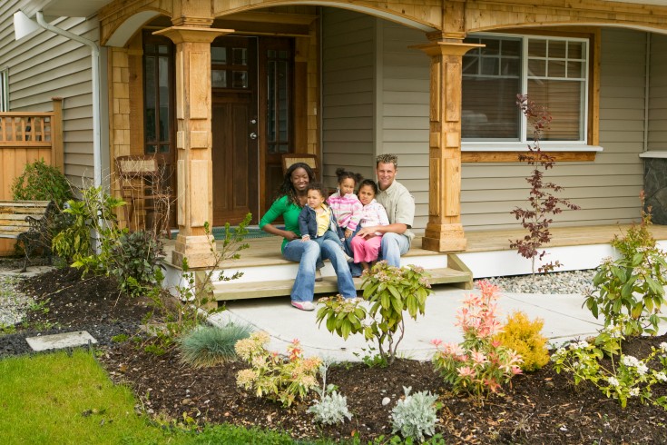 family on the front steps of their new home