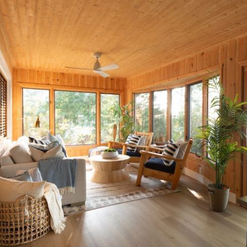 coastal style living room with wood paneling and furniture