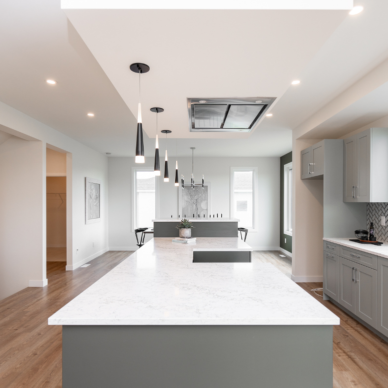 An open concept kitchen with an island range and a flush mount range hood above