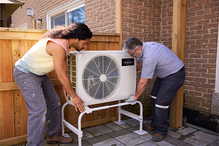 A high-efficiency heat pump being installed at someone's home