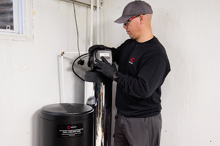 An Enercare professional installing a water softener in a home