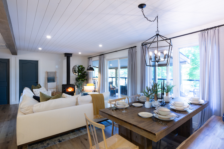 Open concept living room with fireplace and windows to porch