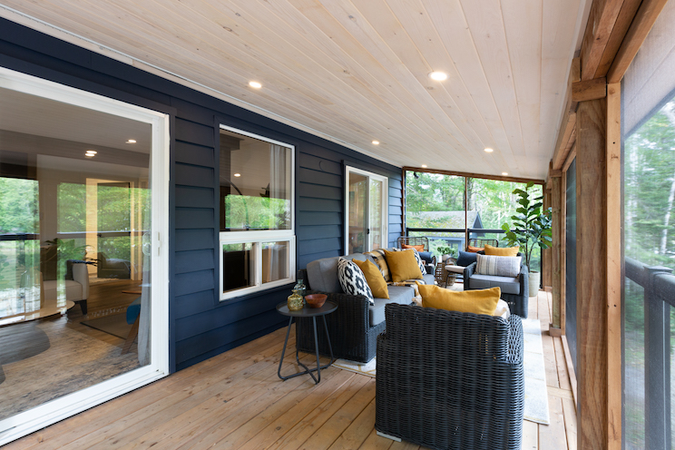 Screened in porch with blue siding and wicker seating