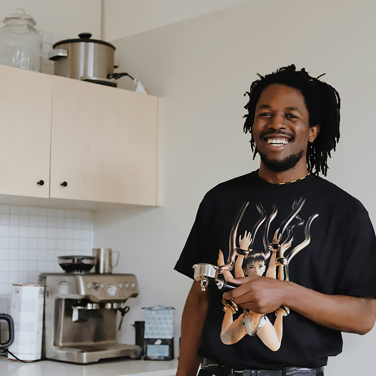 A man laughing as he makes his morning coffee at home in his kitchen