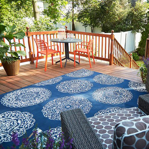 blue outdoor patterned rug with orange chairs outside backyard summer fiddle leaf fig plant