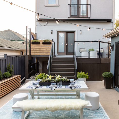 city backyard patio set with clean outdoor rug and string lights