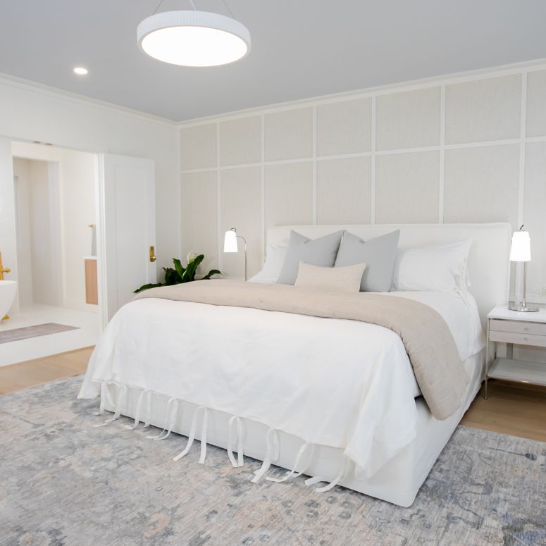 White primary suite bedroom with ensuite