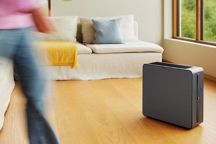 Person walking in living room with Renew Air Purifier on the side