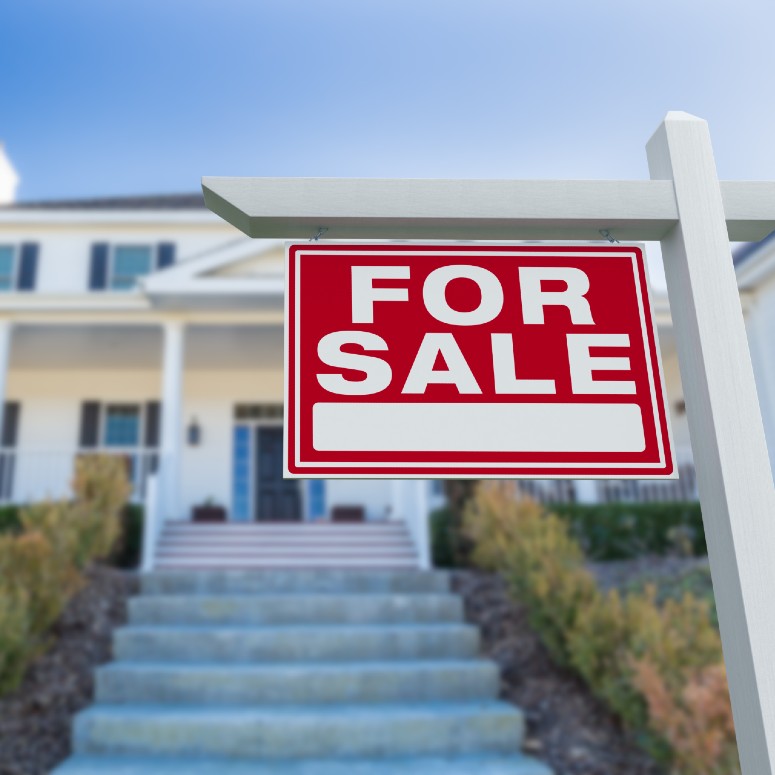 for sale sign in front of a house