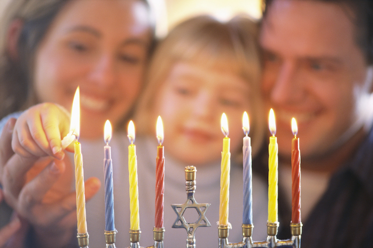 Family lighting a menorah