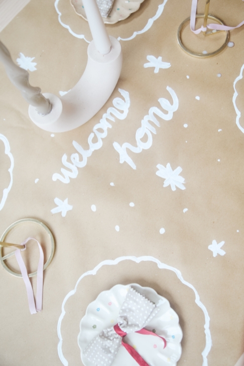 a handwritten welcome home tablescape with plates 