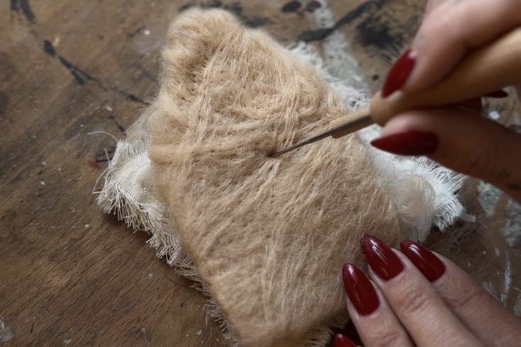 Create a house shape with wool and a felting needle
